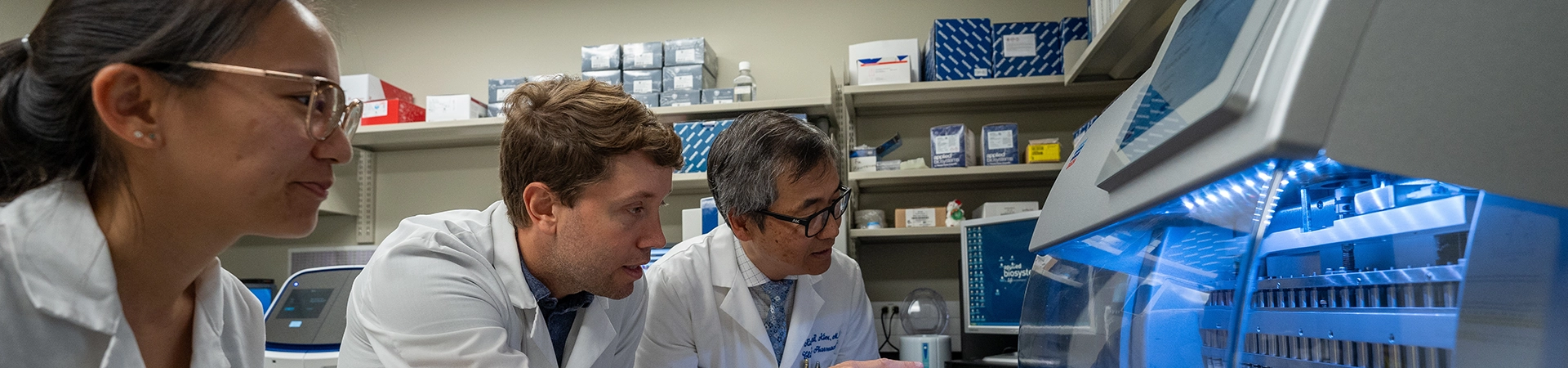 Richard Kim works with graduate students during an experiment